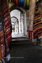 Image du Maroc Professionnelle de  Marchand de tapis à l'entrée du souk de Dlala des tapis et produits de l'artisanat marocain à la cité des Habous. Parmi les endroits les plus pittoresques de Casablanca, la Cité de Habous conçue par les architectes Auguste Cadet et Edmond Brion d’après l’ébauche d’un premier plan-masse dû à Albert Laprade. La construction n’avait commencé qu’après la première guerre mondiale. Situé près du Palais Royale, ce joyau architectural est le point de départ de la nouvelle médina de la ville, Vendredi 18 Novembre 2011. Le quartier des Habous fait partie du patrimoine architectural de Casablanca (Photo / Abdeljalil Bounhar)